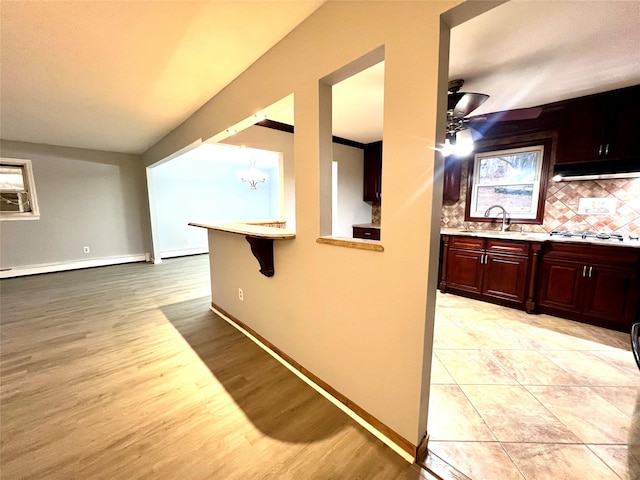 interior space featuring a notable chandelier, light wood-type flooring, sink, and a baseboard radiator