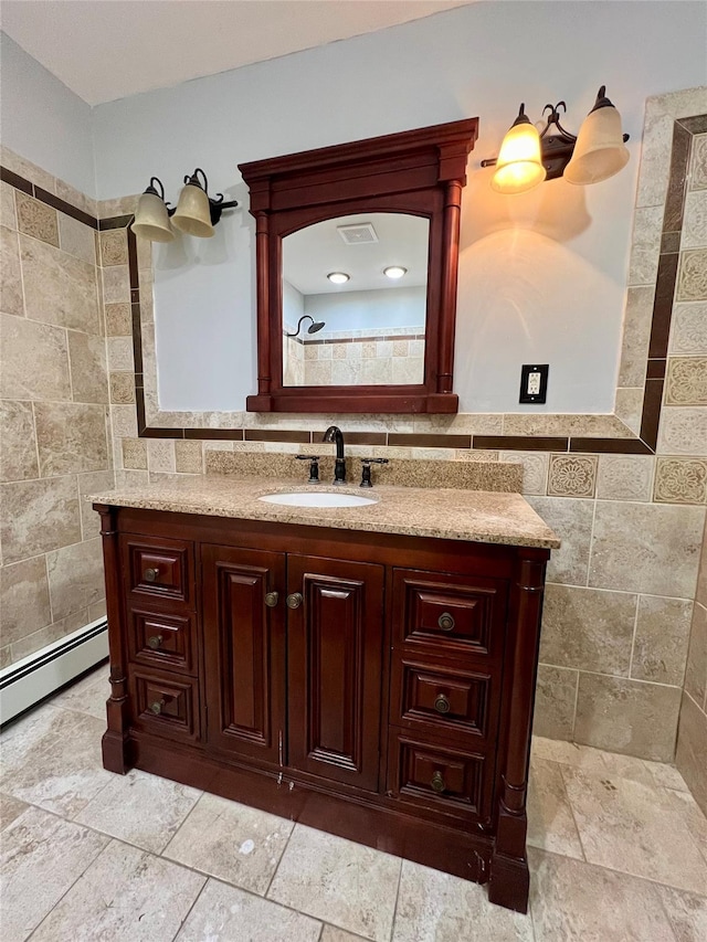 bathroom with vanity, baseboard heating, and tile walls