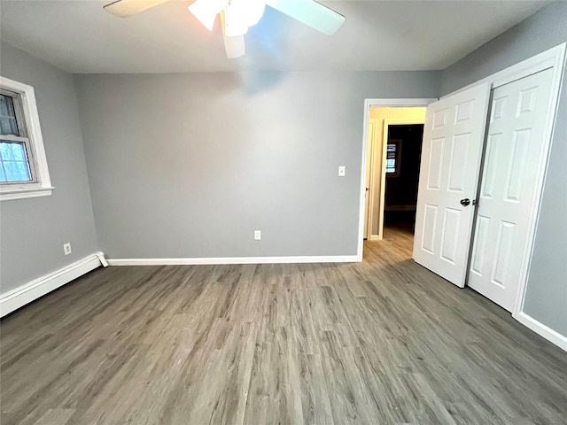 spare room with baseboard heating, ceiling fan, and wood-type flooring