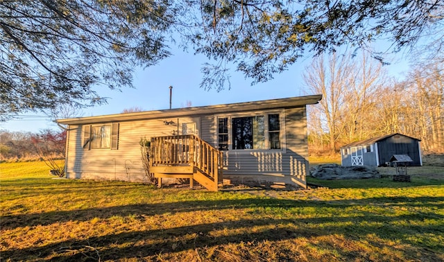 rear view of property with a lawn and a shed