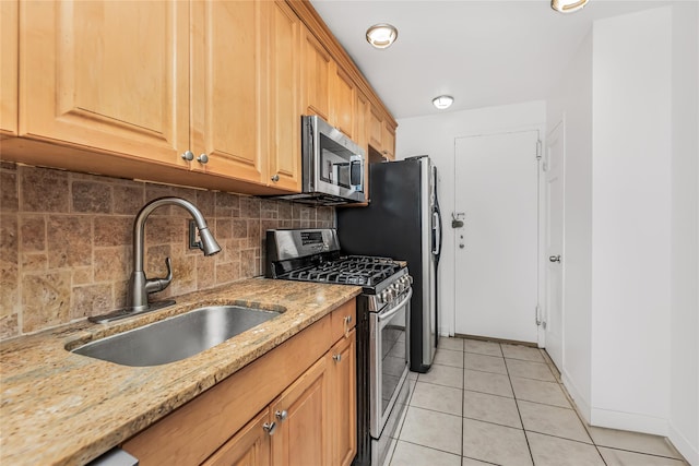 kitchen featuring sink, decorative backsplash, light tile patterned floors, appliances with stainless steel finishes, and light stone counters