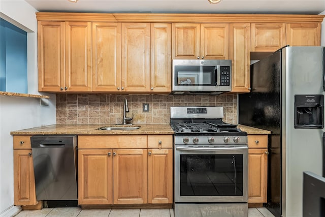 kitchen featuring light stone counters, sink, light tile patterned floors, and appliances with stainless steel finishes