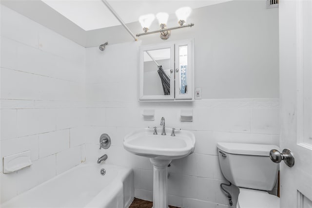 bathroom featuring shower / tub combination, tile walls, and toilet