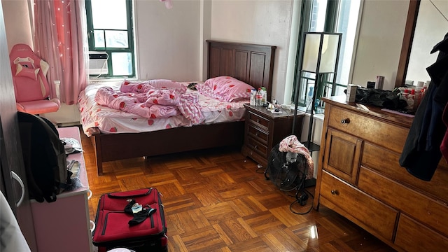 bedroom with dark parquet floors and cooling unit