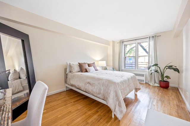 bedroom with light hardwood / wood-style flooring and radiator