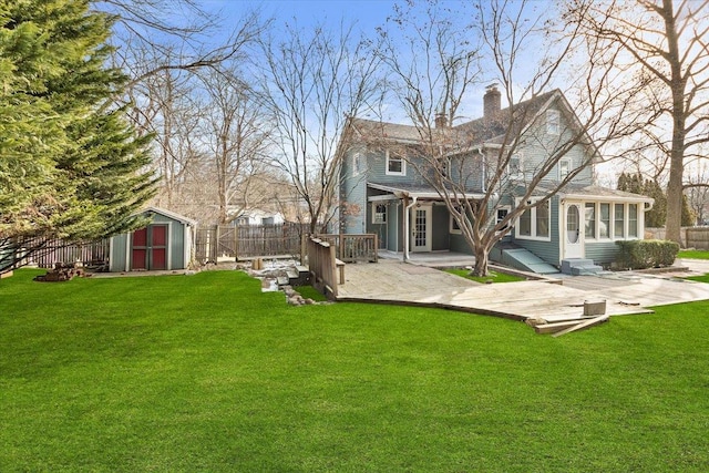 back of house featuring a patio, a shed, and a lawn