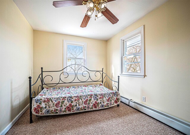 bedroom with ceiling fan, carpet, and a baseboard radiator