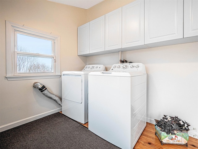 clothes washing area with cabinets and washing machine and dryer