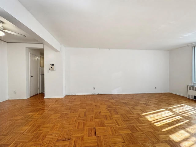 unfurnished room with radiator and light parquet flooring