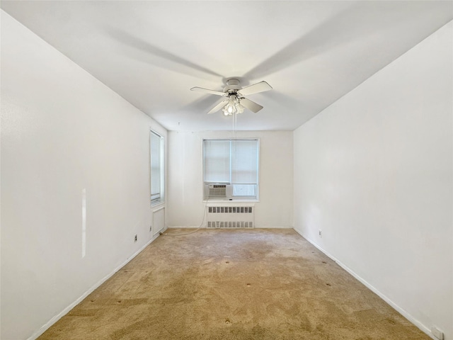 carpeted spare room featuring ceiling fan and radiator