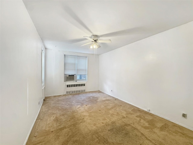 carpeted empty room with radiator and ceiling fan