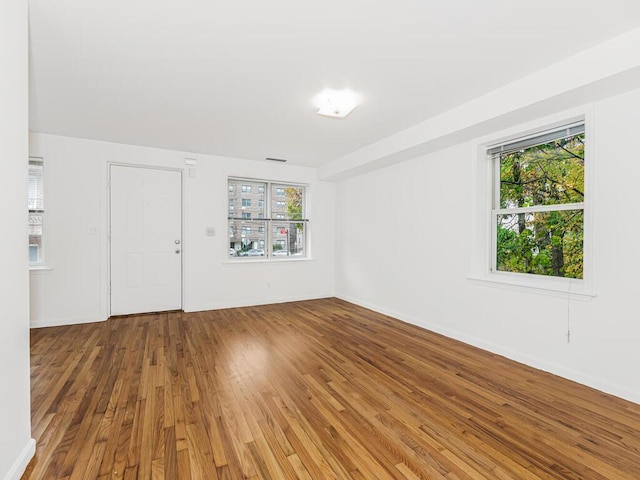 spare room featuring hardwood / wood-style floors and a healthy amount of sunlight