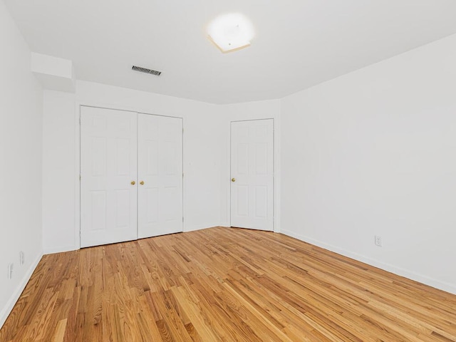 unfurnished bedroom featuring light wood-type flooring and a closet