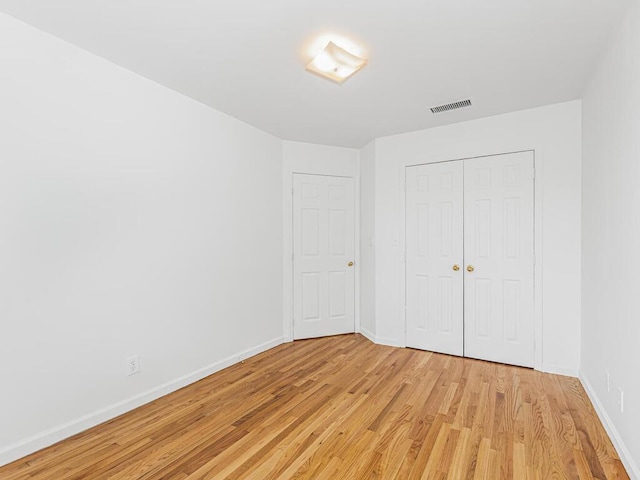 unfurnished bedroom featuring light hardwood / wood-style floors and a closet