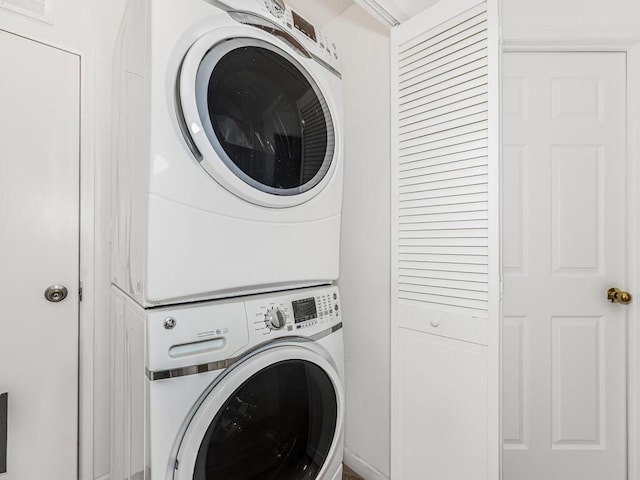 washroom with stacked washing maching and dryer