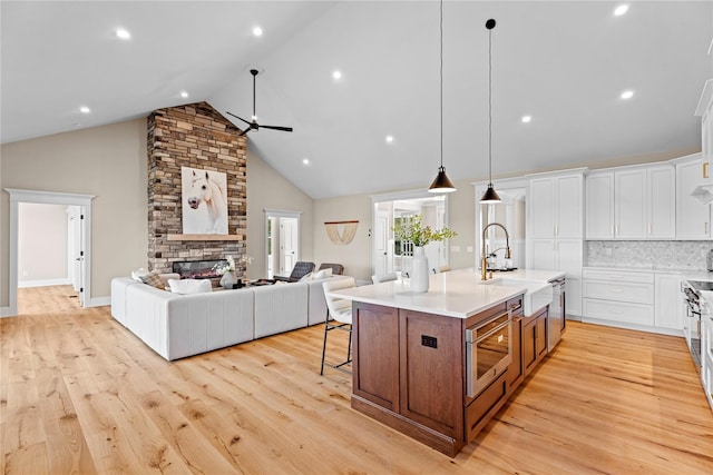 kitchen with pendant lighting, a center island with sink, light hardwood / wood-style flooring, and sink