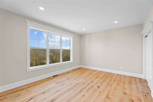 empty room with plenty of natural light and light hardwood / wood-style floors