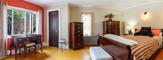 bedroom featuring radiator and light hardwood / wood-style floors