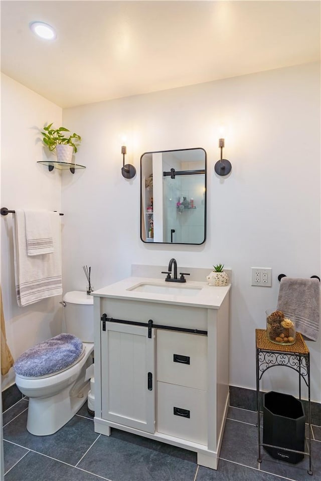 bathroom with toilet, tile patterned flooring, and vanity