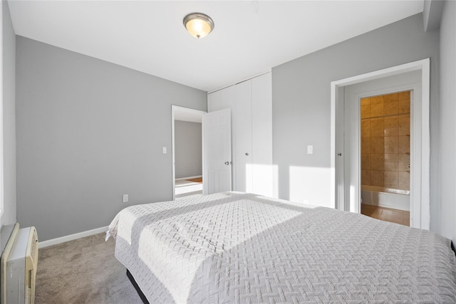 carpeted bedroom featuring ensuite bathroom and a closet