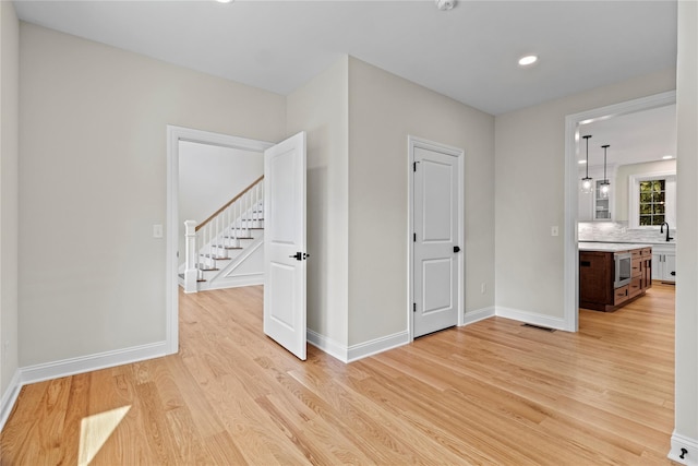 spare room featuring light hardwood / wood-style flooring and sink