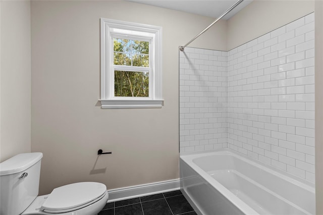 bathroom with tile patterned flooring, tiled shower / bath combo, and toilet