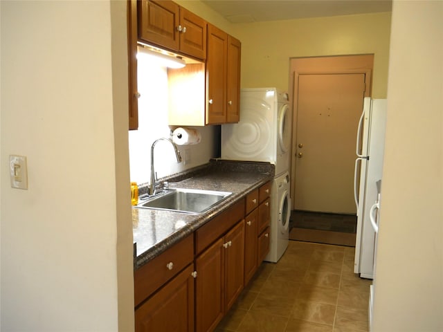 kitchen featuring white fridge, sink, stacked washer / dryer, and light tile patterned flooring