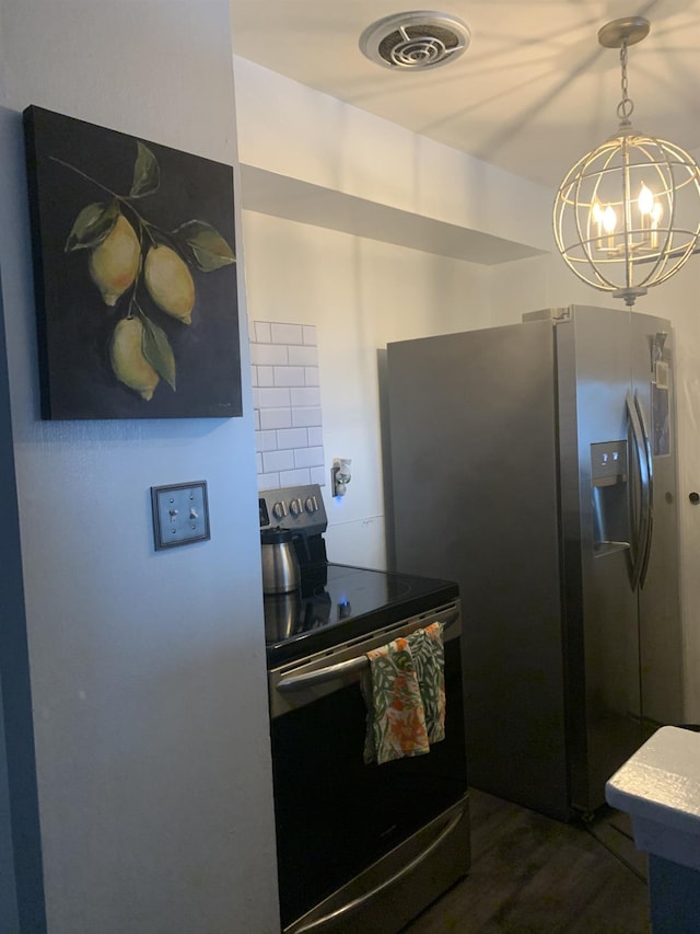 kitchen with dark wood-type flooring, a notable chandelier, and appliances with stainless steel finishes