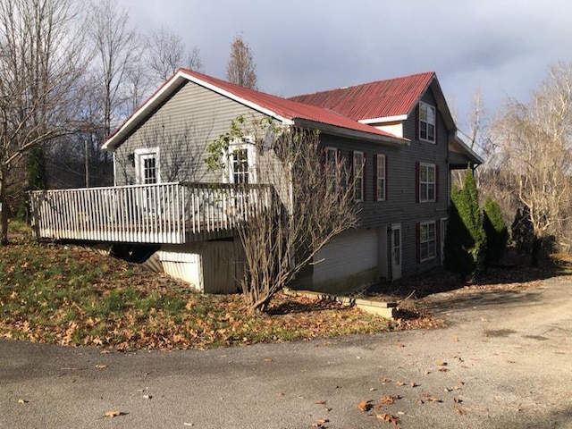 view of home's exterior with a garage and a deck