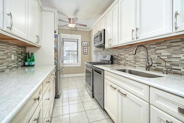 kitchen featuring sink, light tile patterned floors, appliances with stainless steel finishes, light stone countertops, and white cabinets