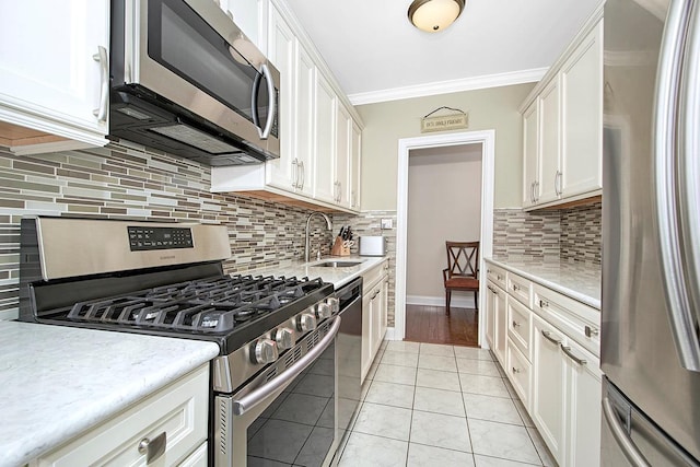 kitchen featuring white cabinetry, appliances with stainless steel finishes, ornamental molding, and light tile patterned flooring