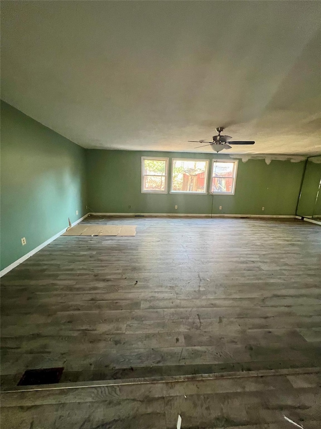 empty room with ceiling fan and dark hardwood / wood-style floors