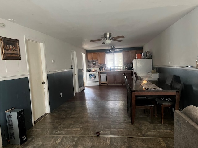 dining area featuring ceiling fan, sink, and a baseboard heating unit