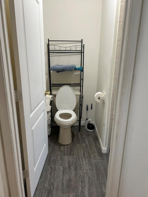 bathroom featuring wood-type flooring and toilet