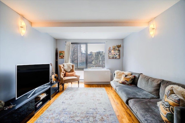 living room with light hardwood / wood-style flooring and beamed ceiling