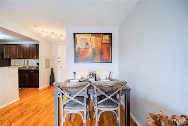 dining room with sink and light hardwood / wood-style flooring