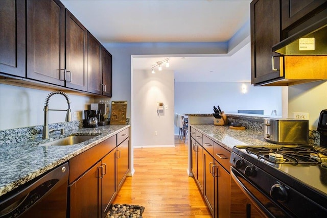 kitchen featuring light stone countertops, black appliances, sink, ventilation hood, and light wood-type flooring