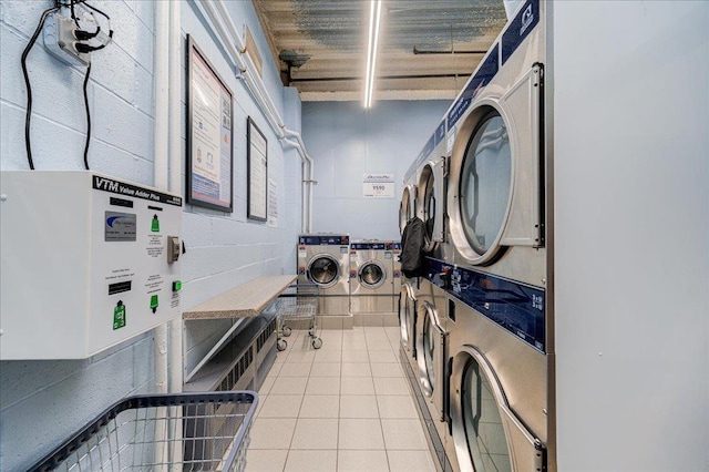 clothes washing area with light tile patterned floors, stacked washer and clothes dryer, and washing machine and clothes dryer