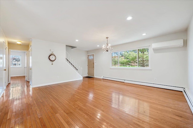 unfurnished living room with a chandelier, light hardwood / wood-style flooring, a baseboard radiator, and a wall mounted air conditioner