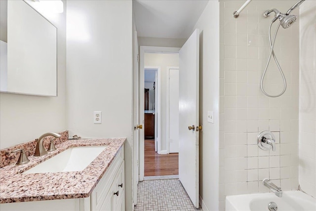 bathroom featuring hardwood / wood-style floors, vanity, and tiled shower / bath