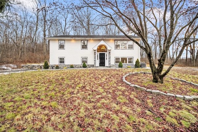 raised ranch featuring a front yard and central AC