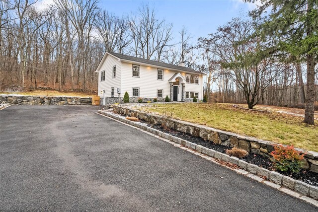 raised ranch featuring a front lawn