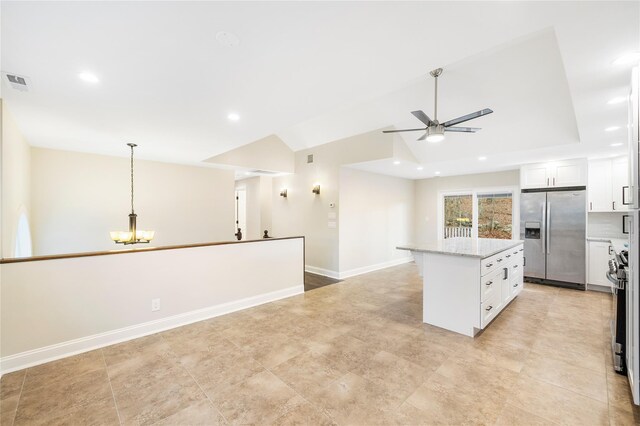 kitchen with white cabinets, light stone counters, pendant lighting, a kitchen island, and appliances with stainless steel finishes