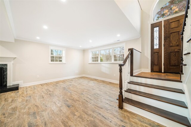 entryway featuring crown molding, plenty of natural light, and light hardwood / wood-style floors