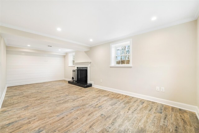 unfurnished living room featuring a large fireplace, light hardwood / wood-style flooring, and ornamental molding