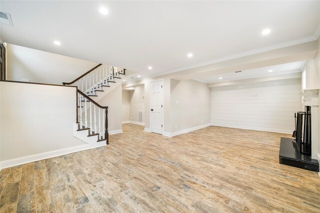 unfurnished living room with light wood-type flooring and crown molding