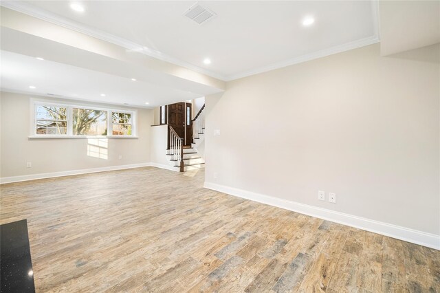 basement with crown molding and light hardwood / wood-style flooring