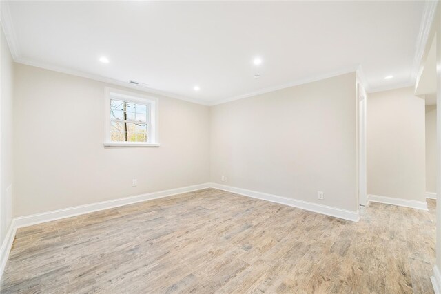 empty room featuring light wood-type flooring and ornamental molding