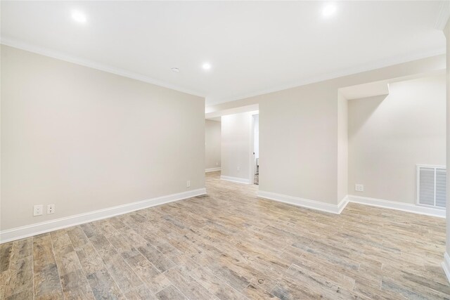 spare room with light hardwood / wood-style flooring and crown molding