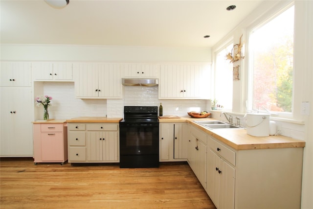 kitchen with sink, black electric range, range hood, butcher block countertops, and light hardwood / wood-style floors